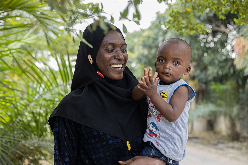 Olanike smiling and holding Muaz after his cleft surgery