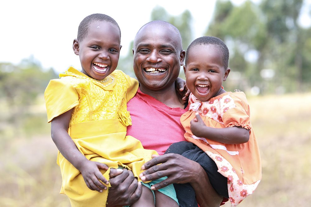 Wesley smiling and holding his daughters after cleft surgery