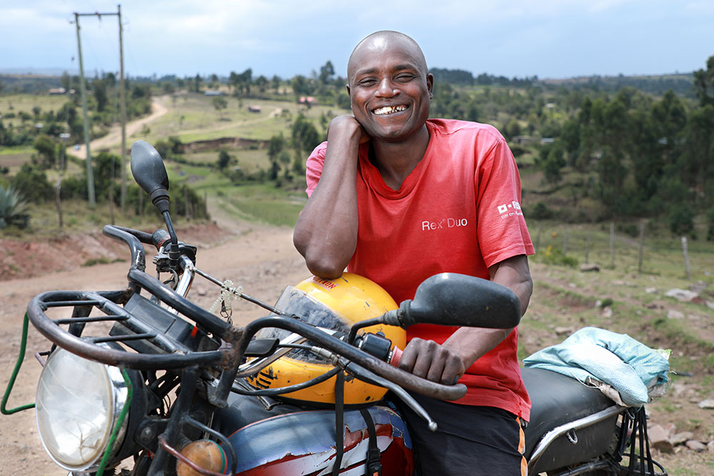 Wesley smiling and riding his boda boda