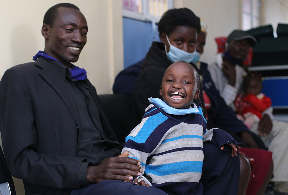 Benjamin smiling with his parents before cleft surgery