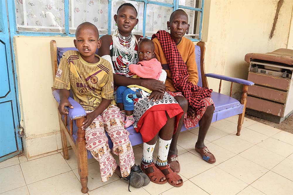 Johana assise avec sa famille avant une opération de fente