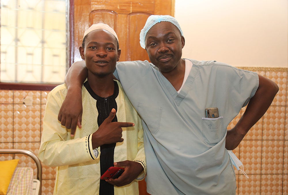 Mohamed's father Amissou smiling and pointing to Professor Mouafo Tambo