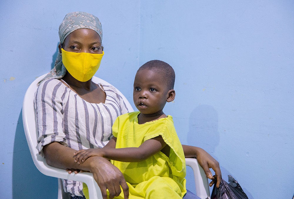 Opeyemi sitting on Deborah's lap in the waiting room before cleft surgery