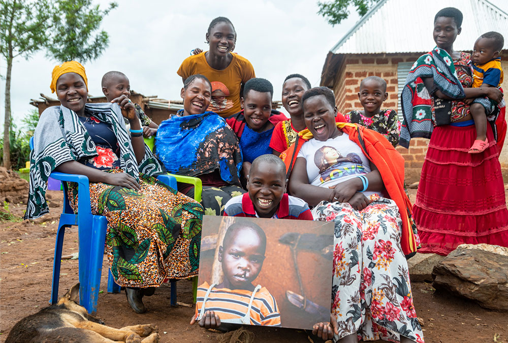 Osawa smiling with his family and holding a photo of himself before cleft surgery