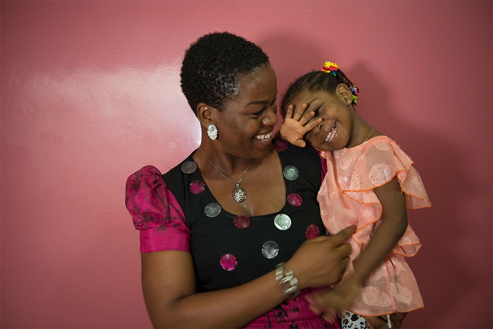 Professor Olugbemiga Ogunlewe smiling and holding a cleft-affected patient