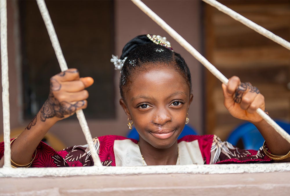 Rawdah smiling and looking out a window after cleft surgery