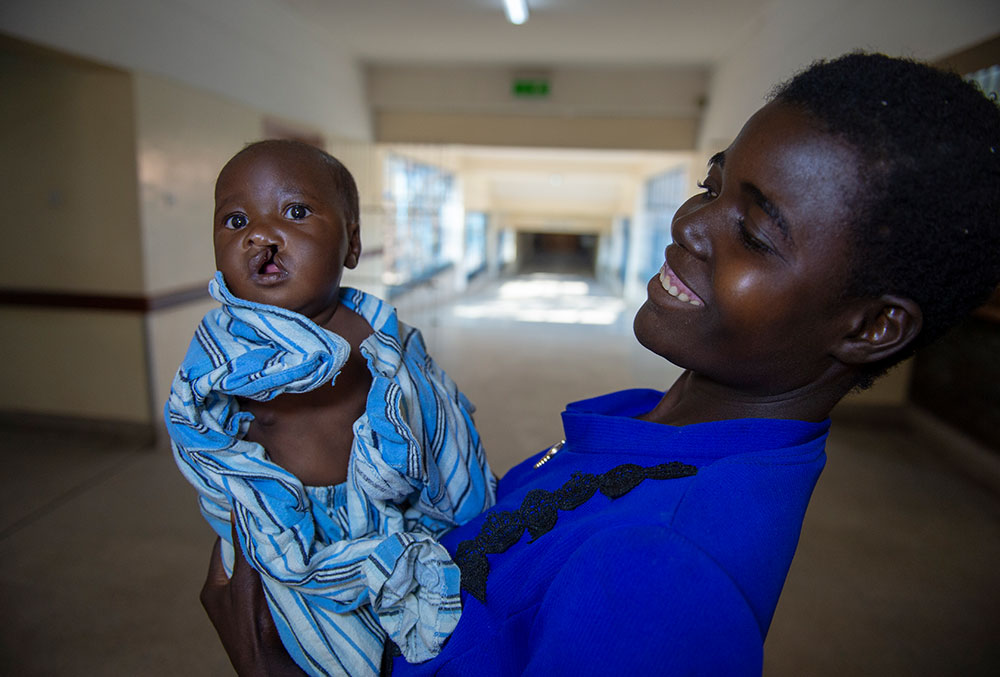 Rosemary smiling and holding Nyasha in the hospital before cleft surgery