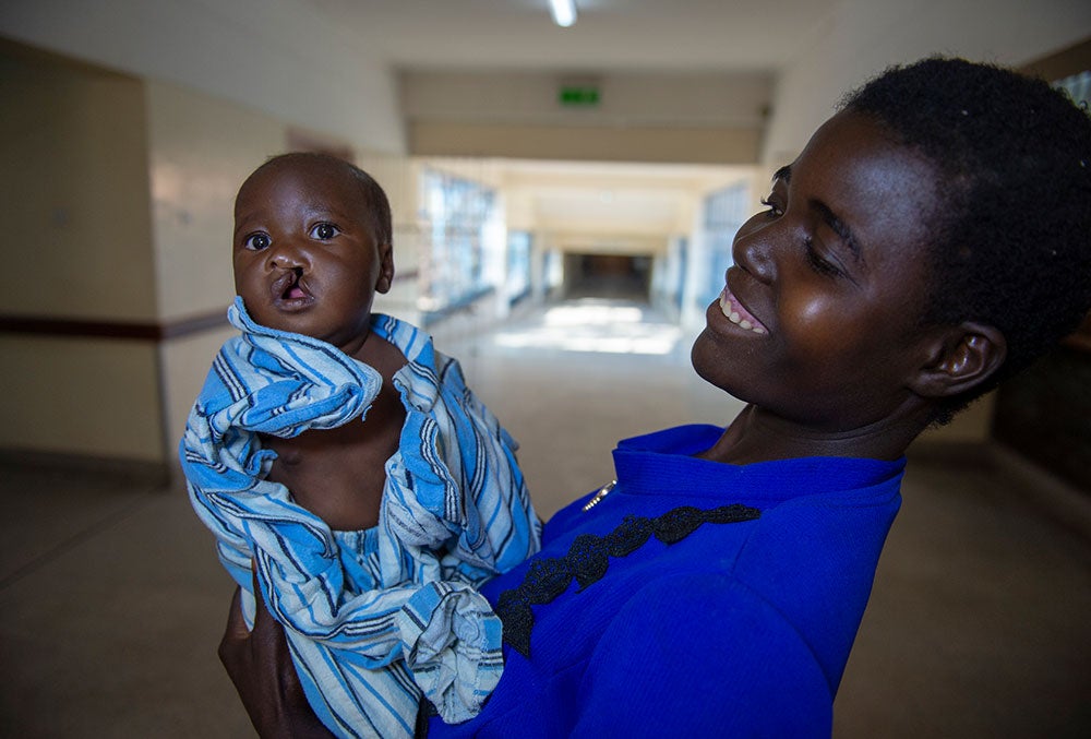 Rosemary smiling and holding Nyasha in the hospital before cleft surgery