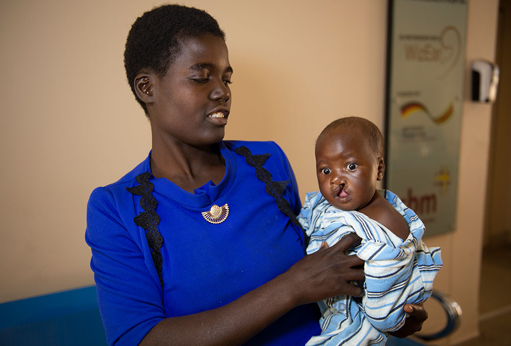 Rosemary smiling and holding Nyasha in the hospital before cleft surgery