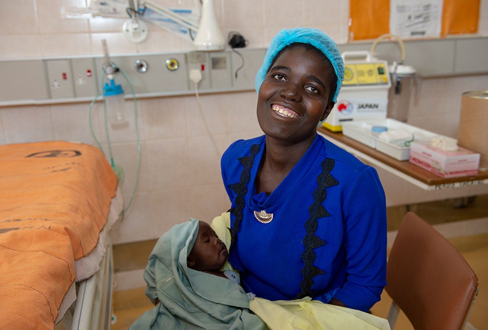 Rosemary holding Nyasha shortly after seeing him for the first time post-surgery