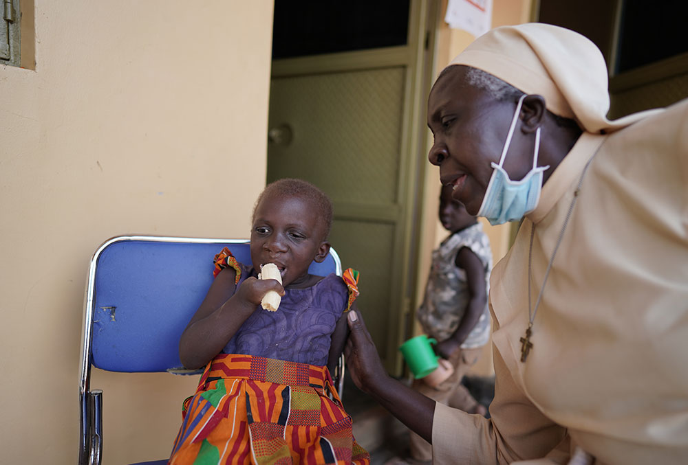 Sister Dr. Liliana Najjuka giving a patient nutritional support after her cleft surgery