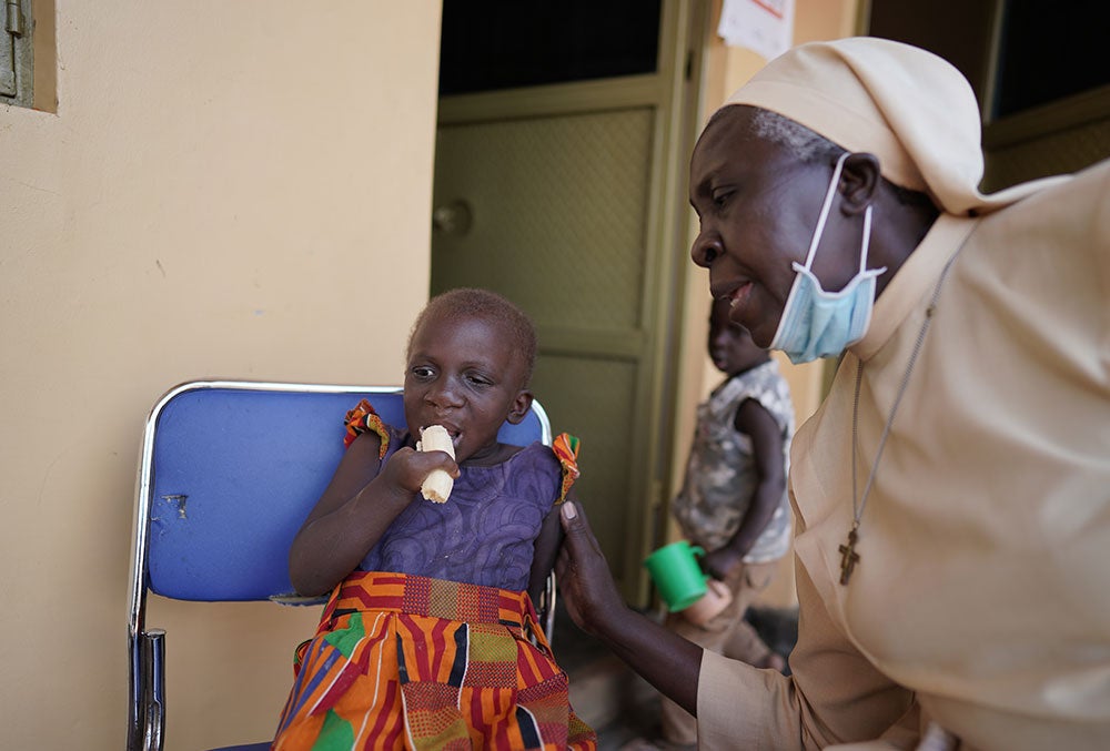 Sister Dr. Liliana Najjuka giving a patient nutritional support after her cleft surgery