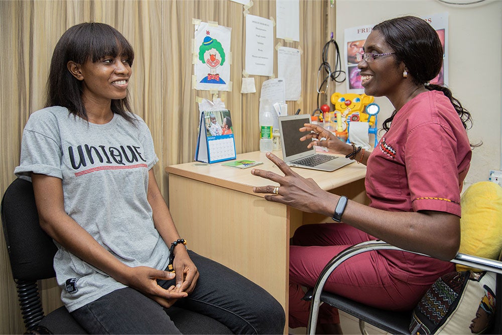 Susanna smiling and speaking with Dr. Olusanya in speech therapy