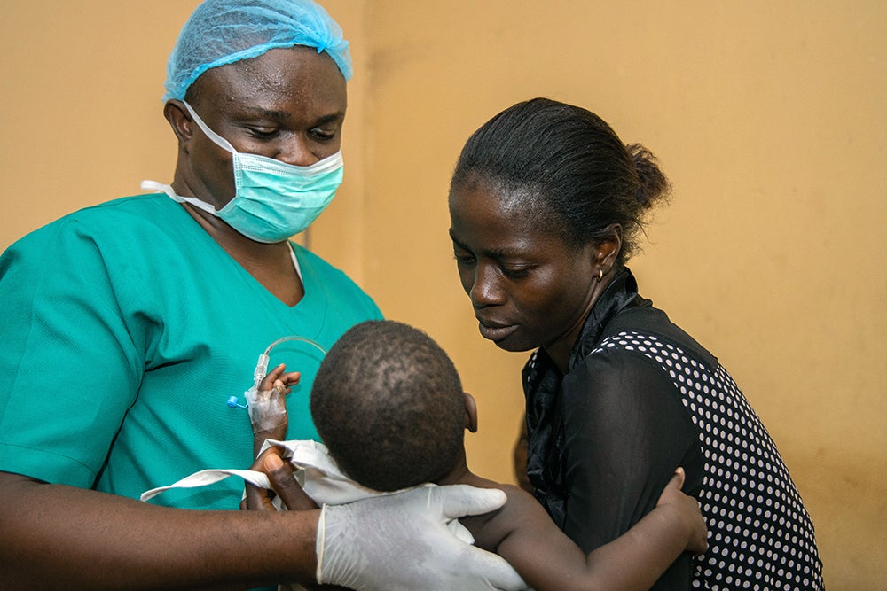 Ugwuoke holding Immaculata with a Smile Train partner at the National Orthopaedic Center