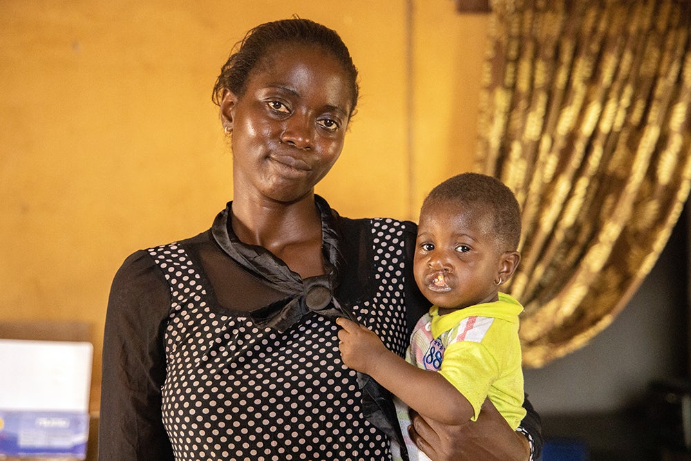 Ugwuoke smiling and holding Immaculata before her cleft surgery