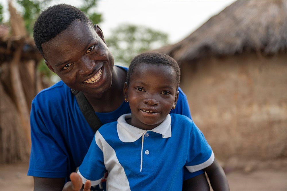 Akuya smiling with her father Kossi after cleft surgery