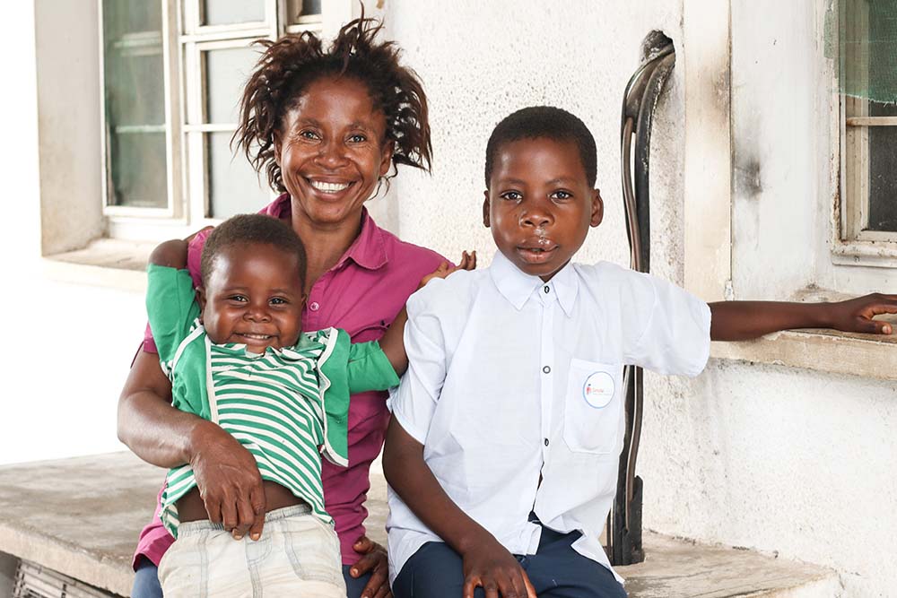 Nkunda souriant avec sa mère Muswamba et son frère après une opération à une fente
