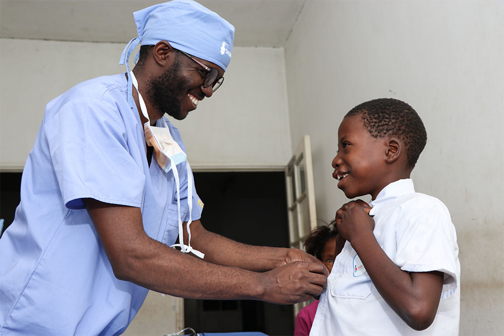 Nkunda smiling and speaking with his cleft surgeon