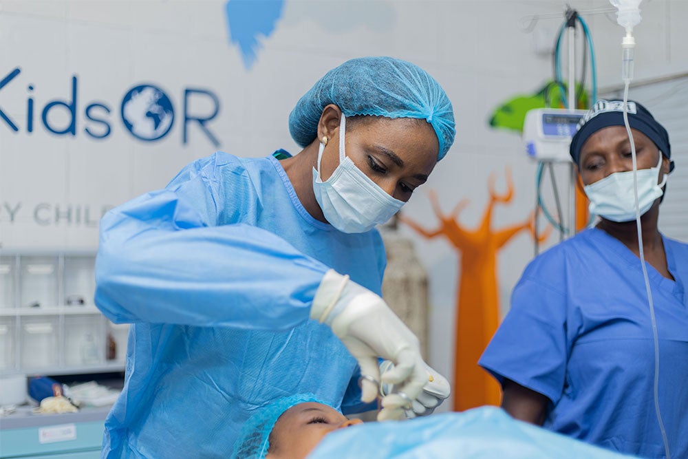 Dr. Oti in scrubs performing cleft surgery in a KidsOR operating room