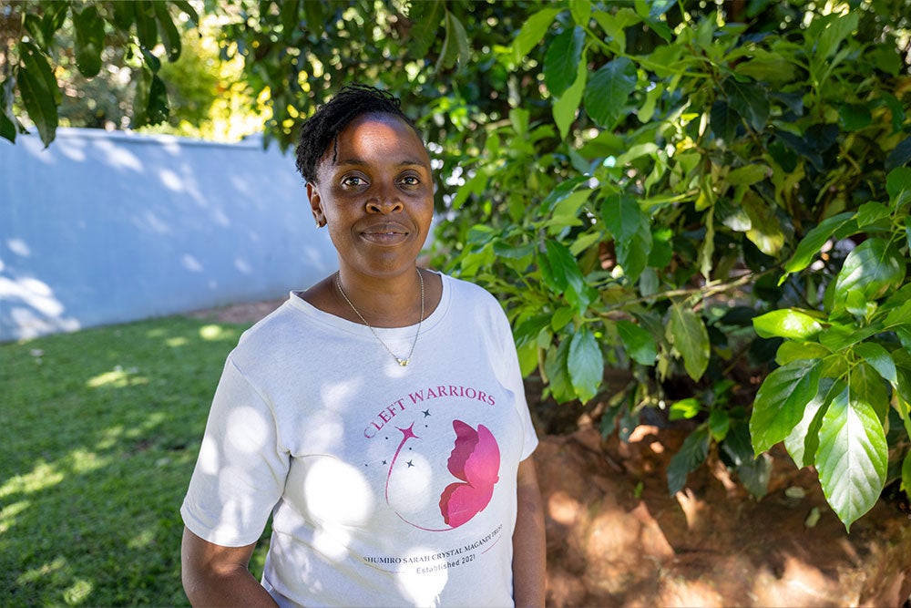 Danai Magandi smiling and wearing a "Cleft Warriors" t-shirt