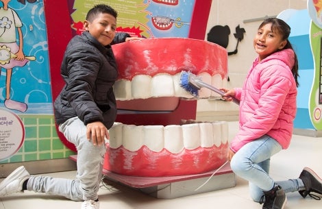 Alex et Kendra démontrent la technique de brossage des dents sur une bouche géante