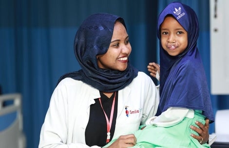 child is comforted by Smile Train staff