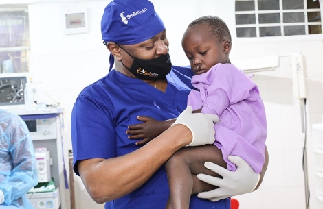 Smile Train medical partner hold boy before surgery