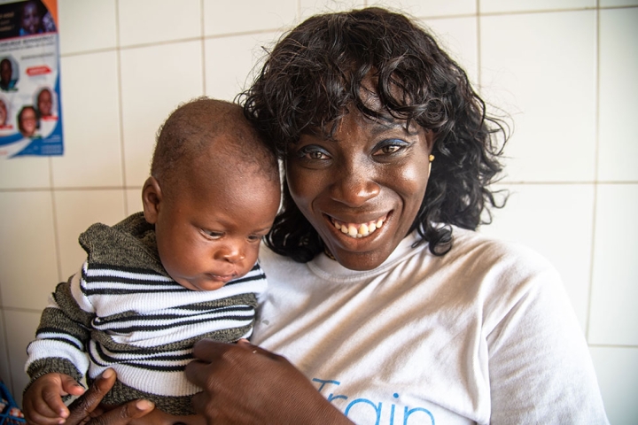 Dr. Nina Capo-Chichi smiling and holding a cleft-affected baby after their cleft surgery