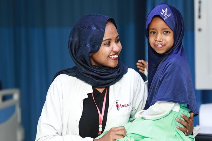 child is comforted by Smile Train staff