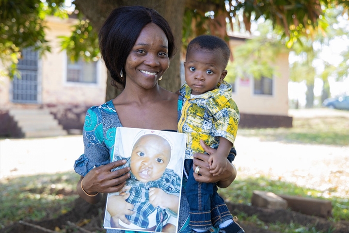 Favour and Annointed smiling and holding a picture of him before cleft surgery