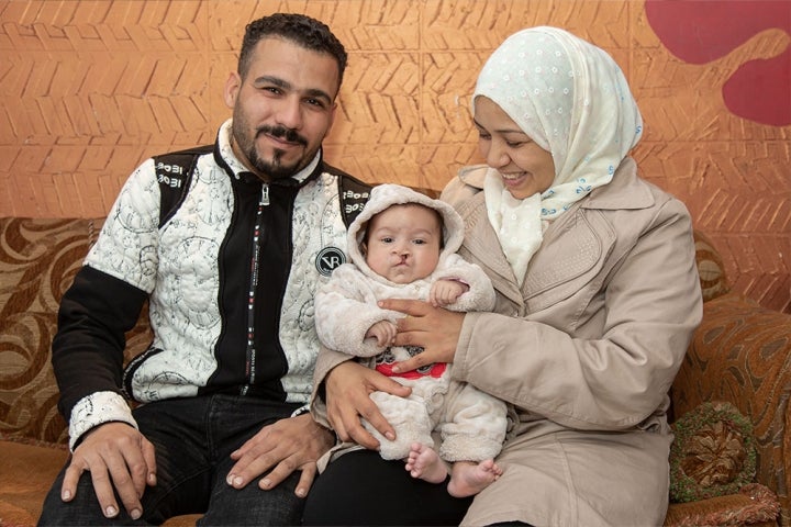 Nagla et Mohamed sourient et tiennent Mustafa dans leurs bras avant une opération de fente