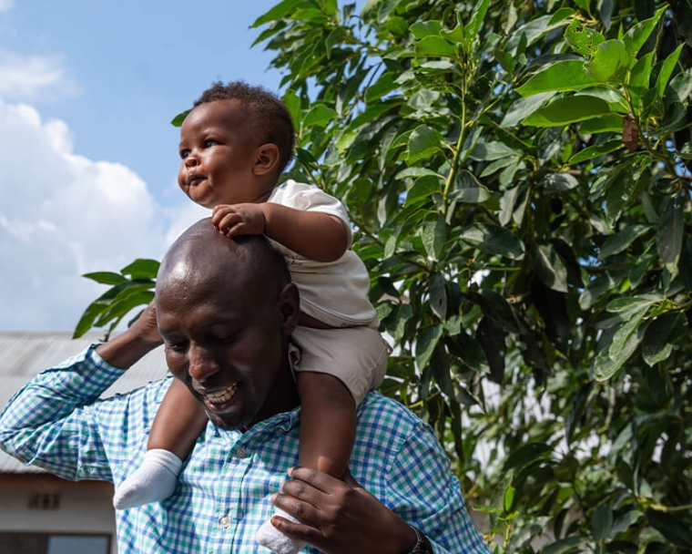 Dr. Amos Zacharia Muzuka carrying child