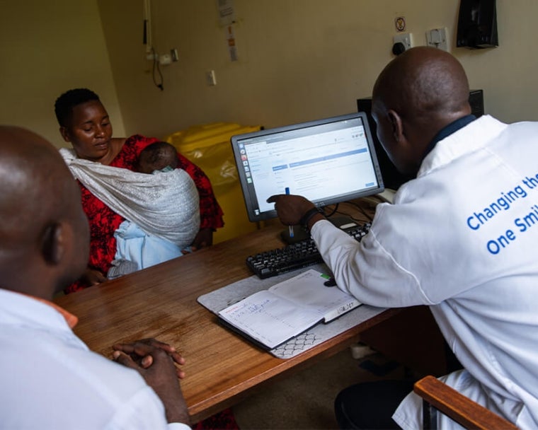 Dr. Amos Zacharia Muzuka with cleft patient and mother