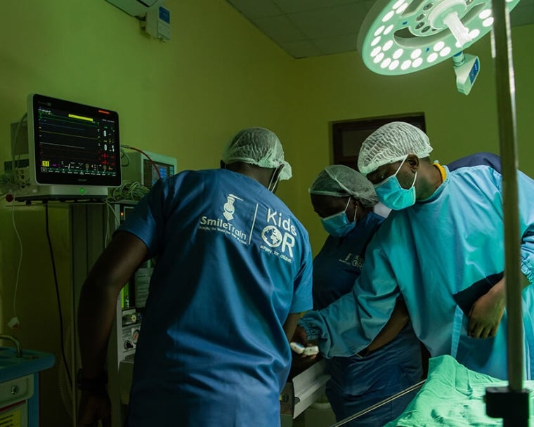 Dr. Amos Zacharia Muzuka with surgeons in KidsOR surgery room